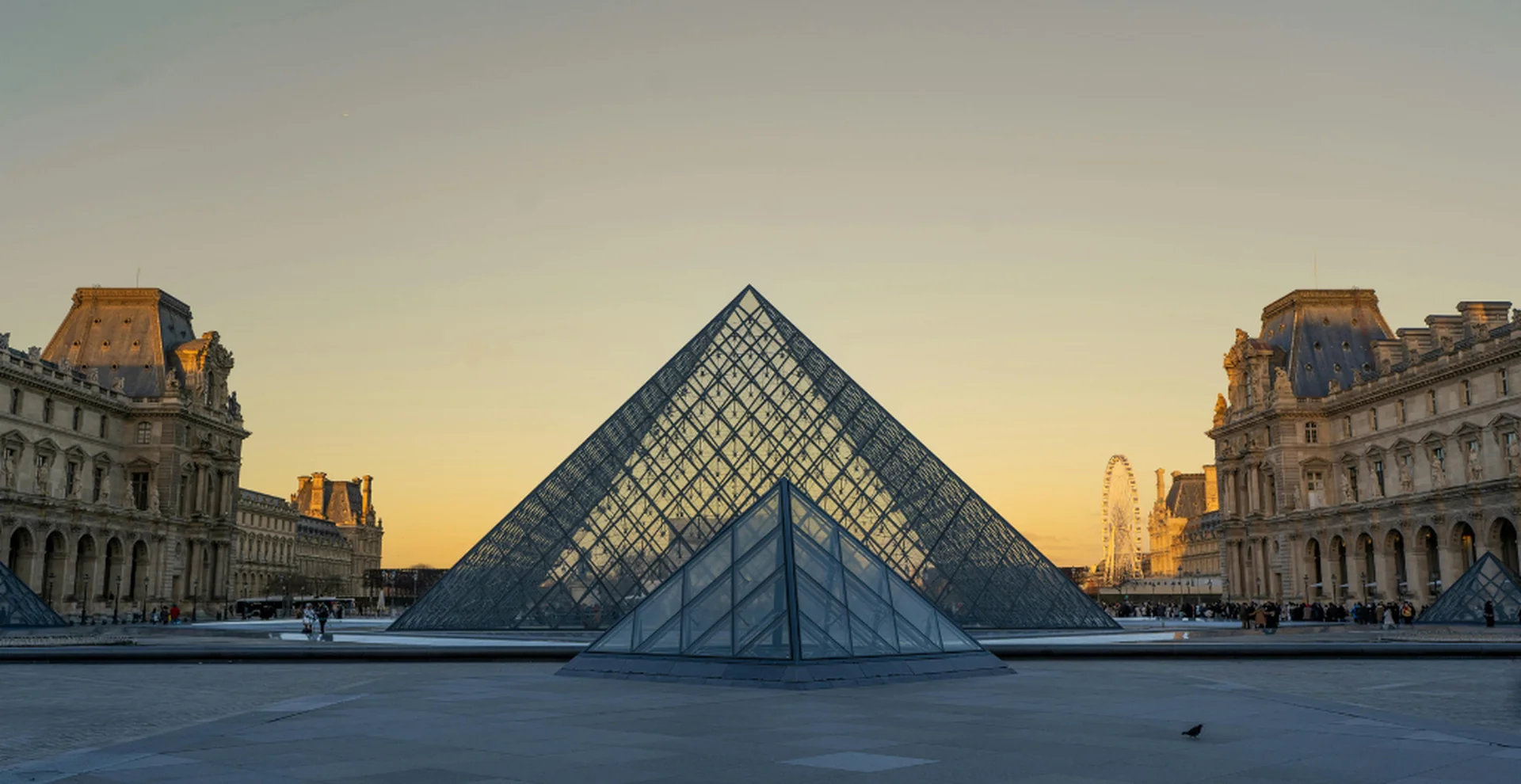 Pyramide du Louvre illuminée au coucher du soleil, incontournable lors d'une visite de Paris en août