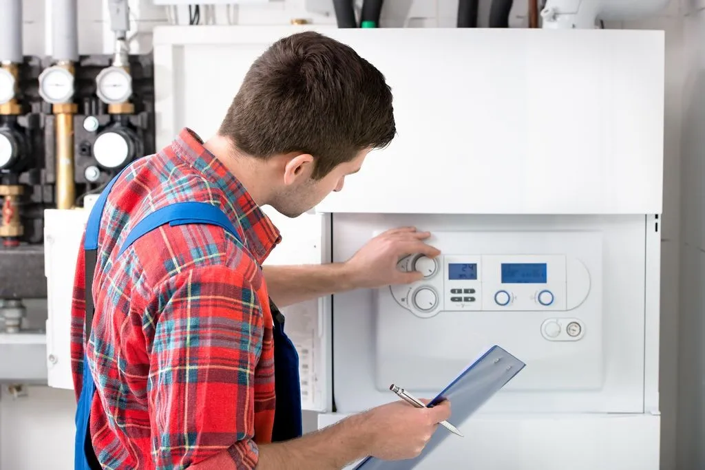 Engineer inspecting and adjusting a residential boiler.