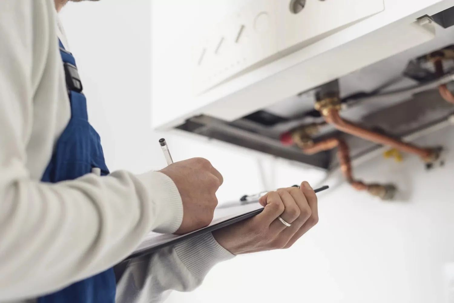 Plumber performing annual check-up on a boiler.