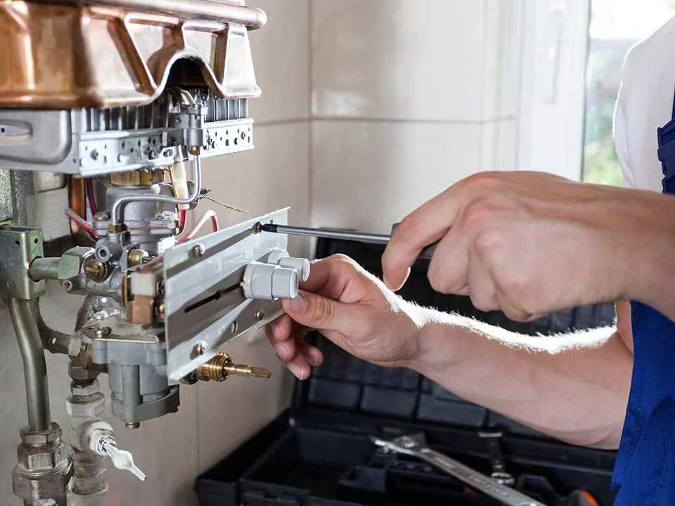 Plumber repairing a wall-mounted water heater.