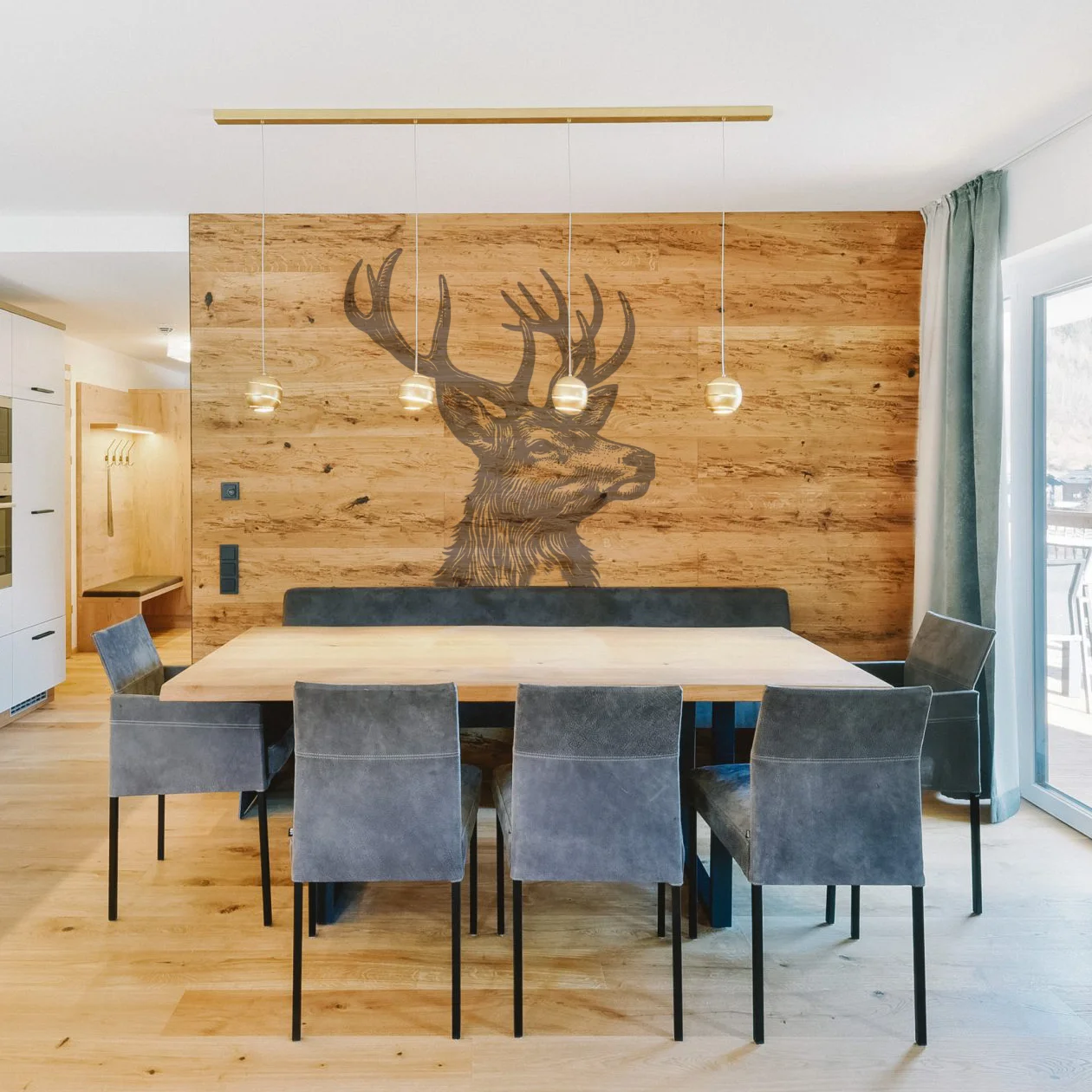 Moderner Essbereich mit Holztisch, grauen Stühlen und einer Holz-Wand mit Hirsch-Motiv.