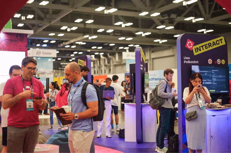 Polkadot conference exhibition floor with Interact booth and blockchain developers networking