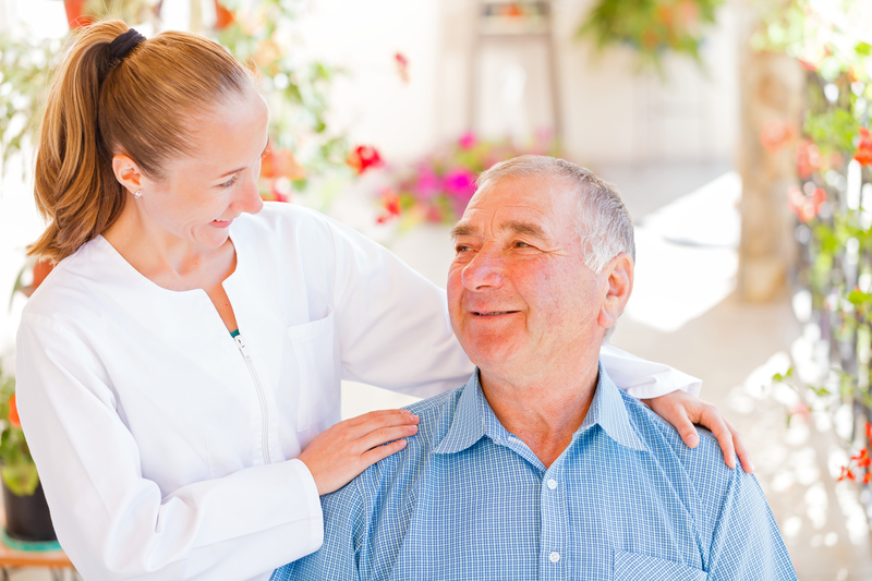 A smiling senior care worker assisting dementia care resident