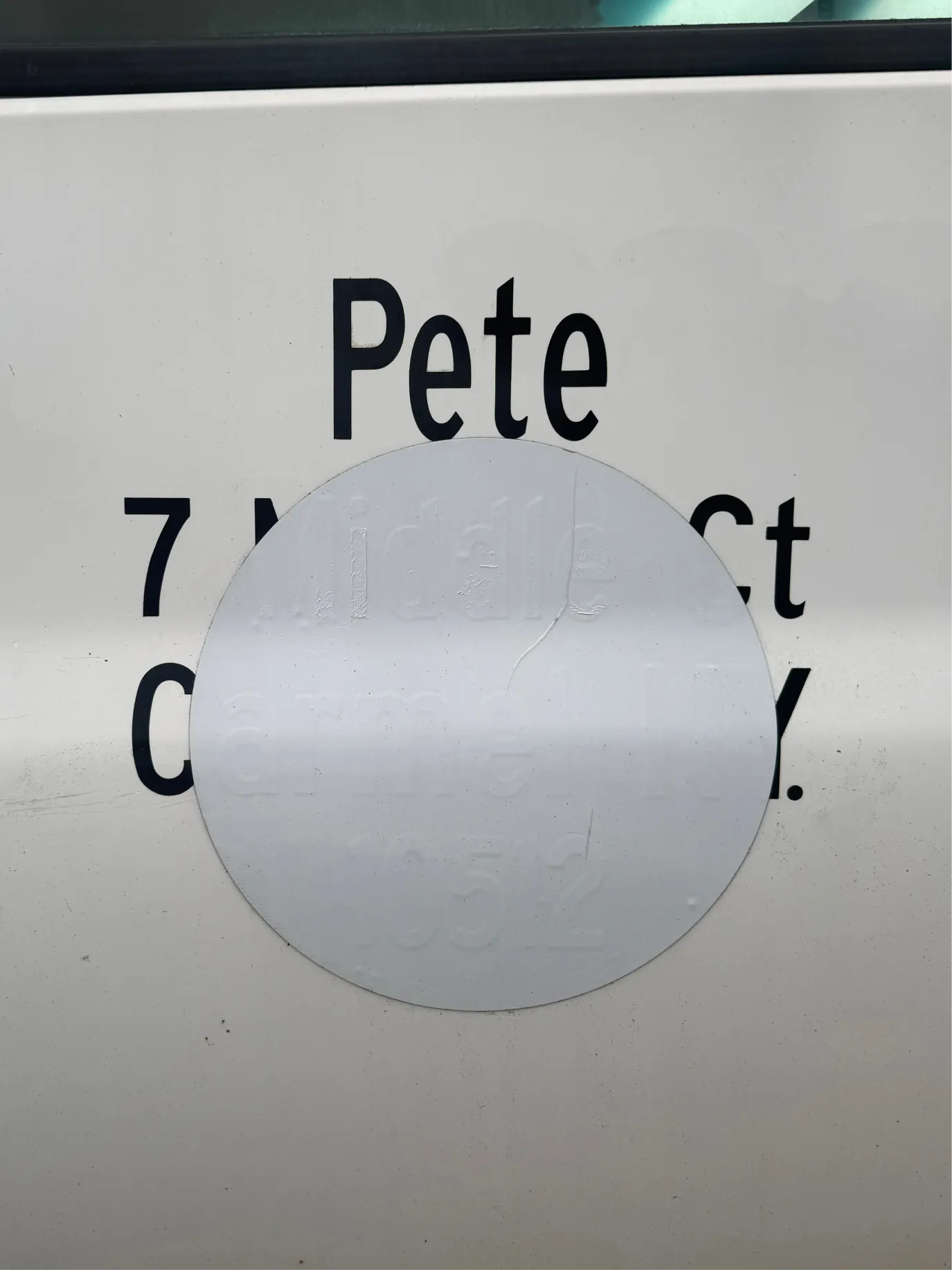 White sign reading Pete, partly covered by a translucent circle