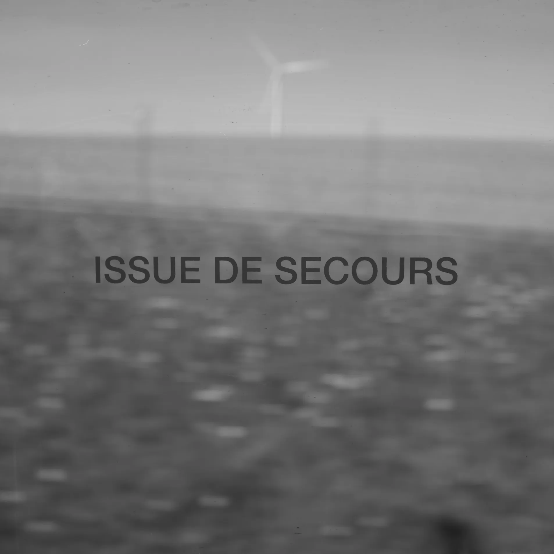 Blurred black and white field with the words Issue de secours