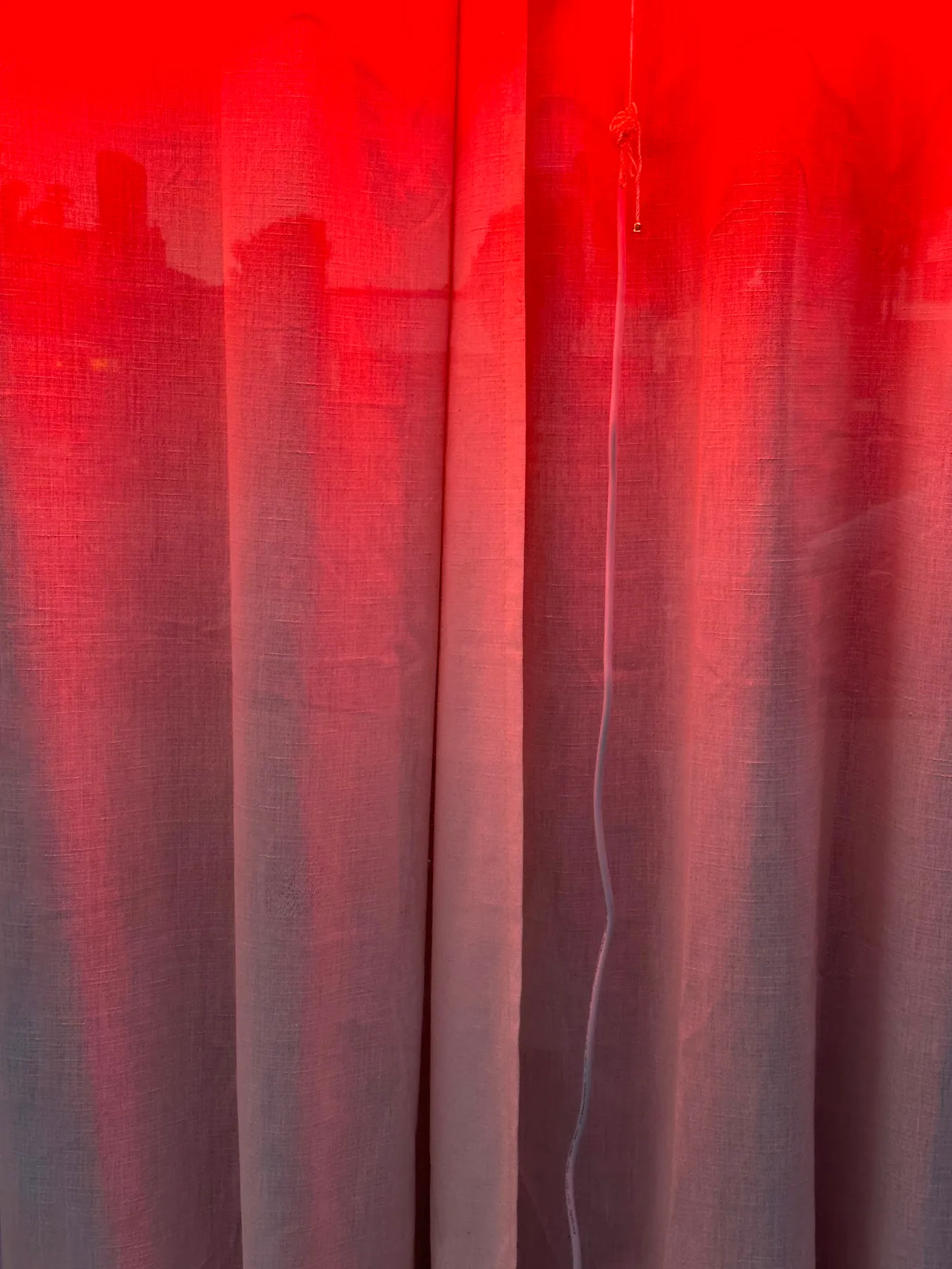 Red light falling on draped curtains