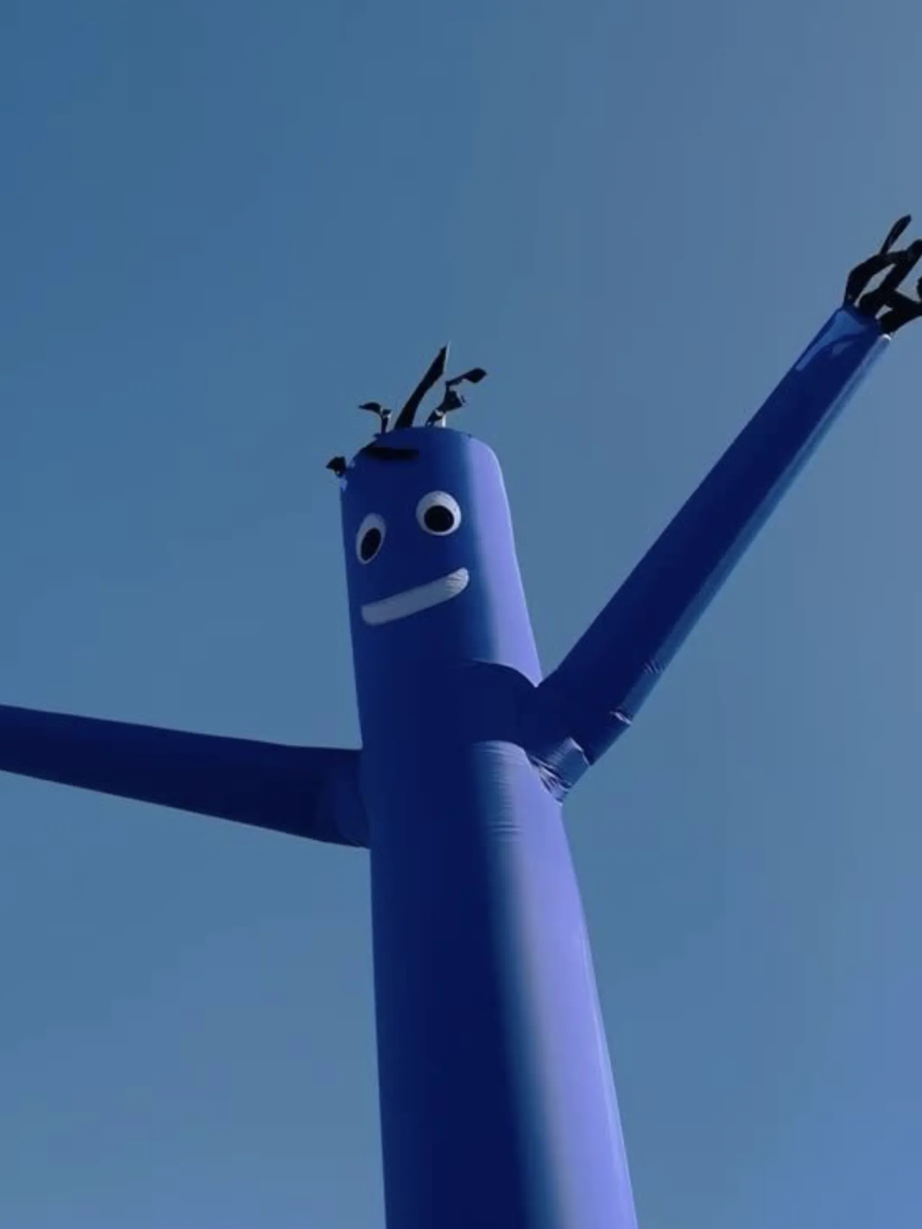 Blue inflatable tube man against a blue sky