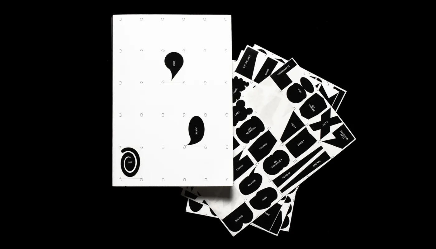 White calendar with three black speech bubble icons labeled 'HIPHOPPE,' 'SURE,' and 'DUPPE' set against a black background, accompanied by several sheets with black and white labels featuring various German words.