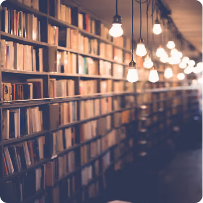 Picture of library shelves with old timey lights hanging down