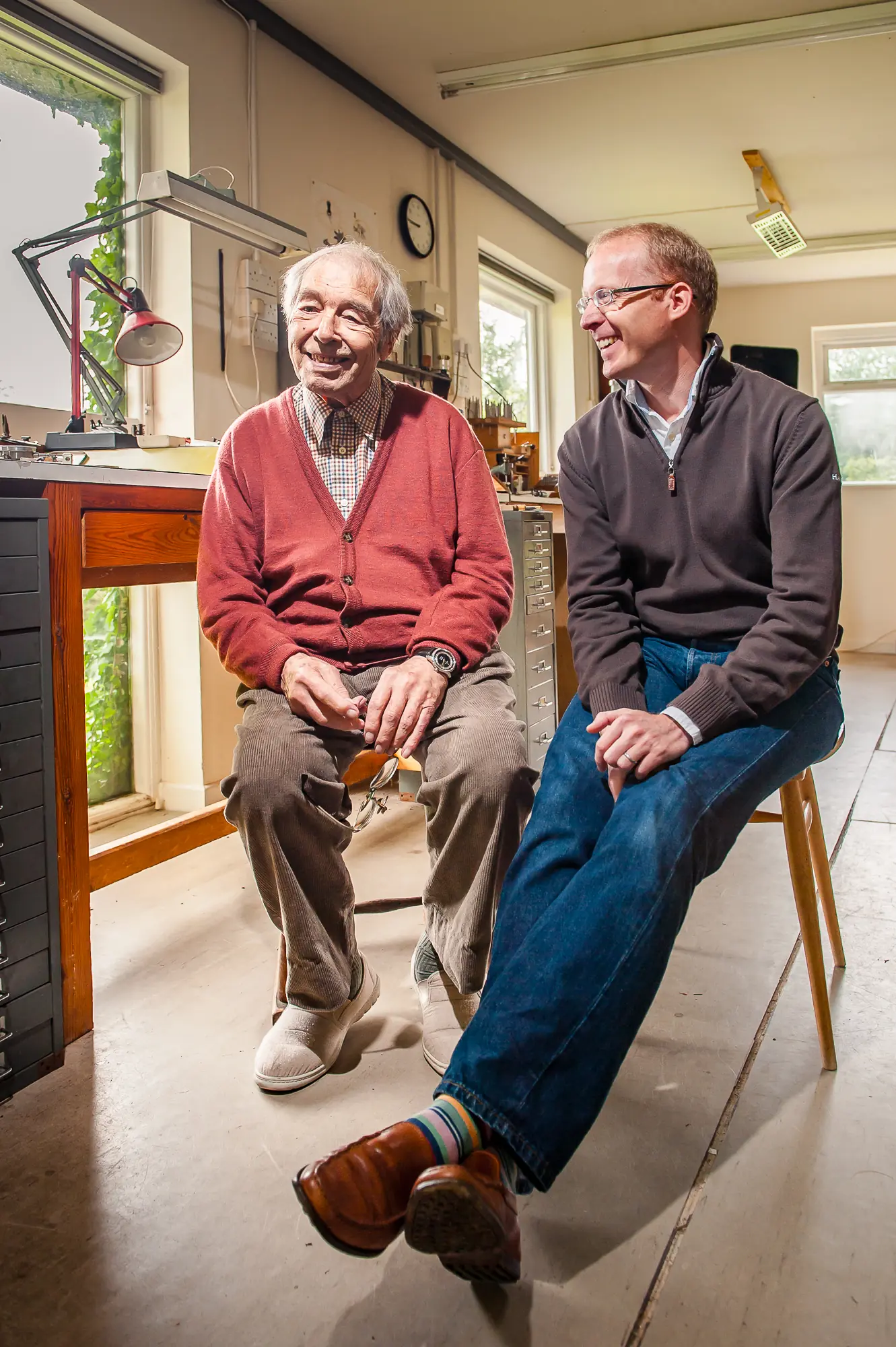 George Daniels and Roger W. Smith laughing together in the Daniels workshop