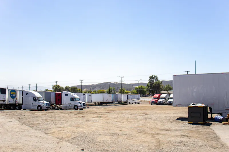 PM service for heavy-duty trucks, showing semi tractors and trailers staged across a large commercial fleet yard.