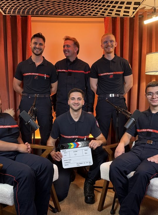 Équipe de sapeurs-pompiers en tournage sur le plateau cosy, clap en main