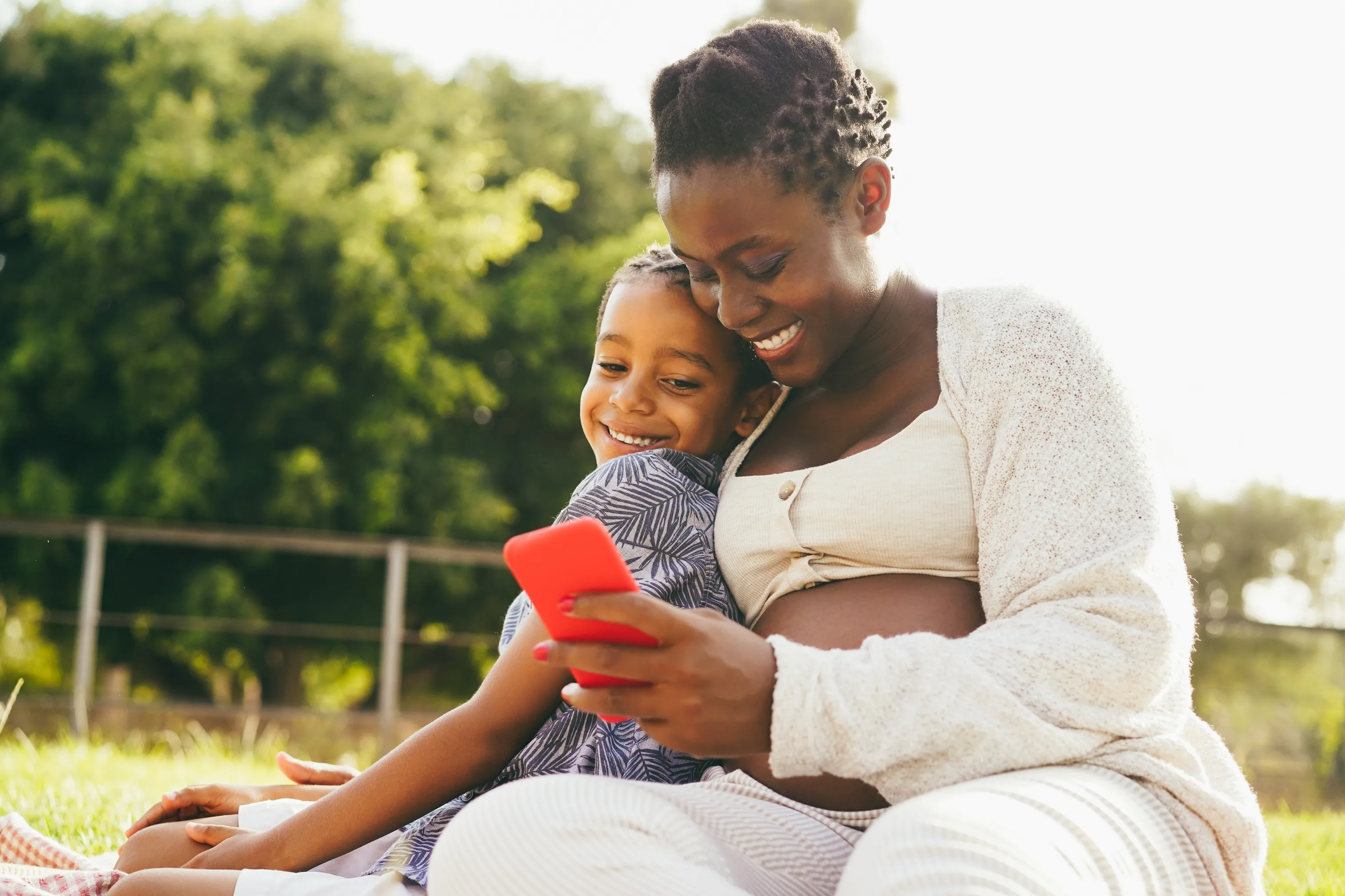 Mother and child sitting outside looking at a phone