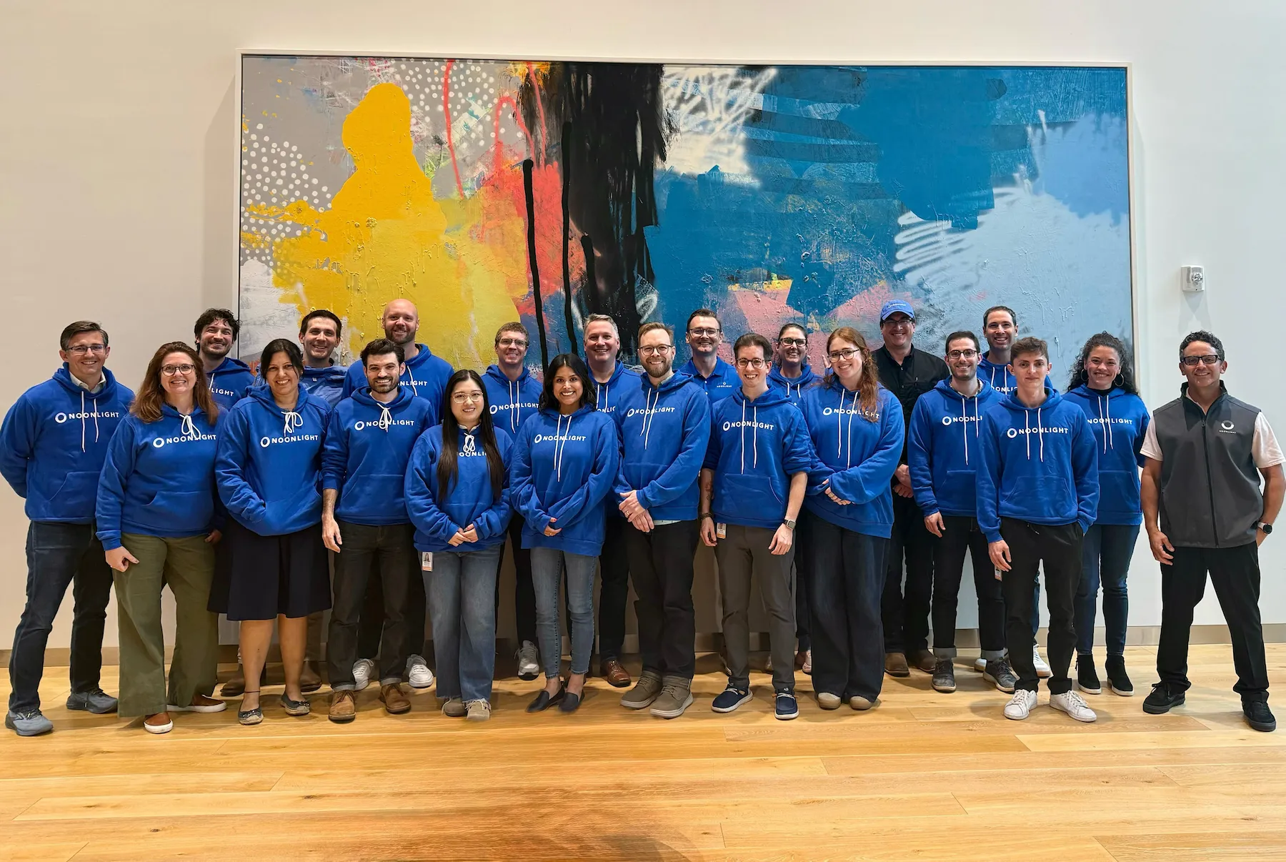 A group of Noonlight employees wearing blue Noonlight sweatshirts.