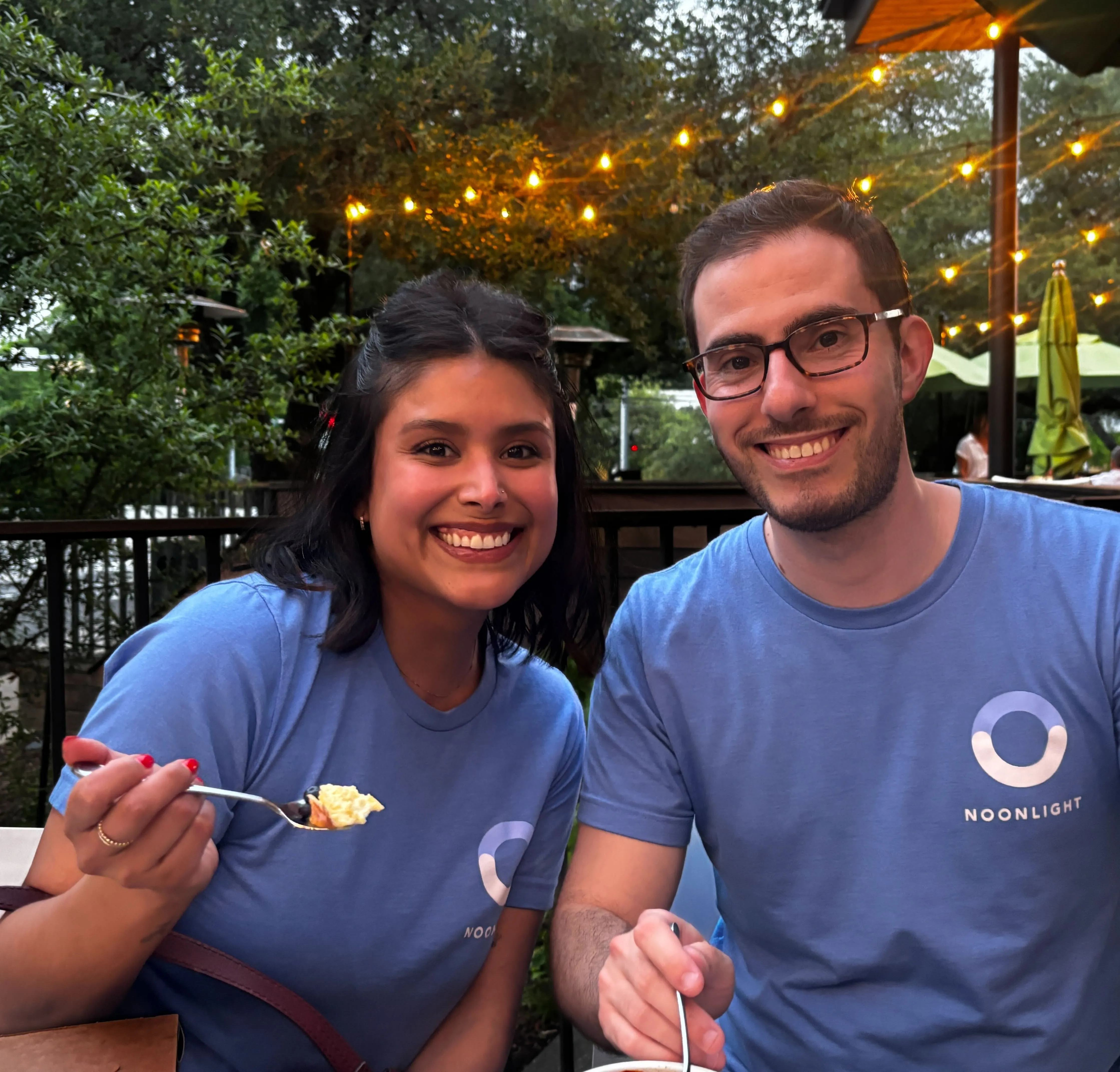 Noonlight employees wearing blue Noonlight shirts at an outdoor restaurant.
