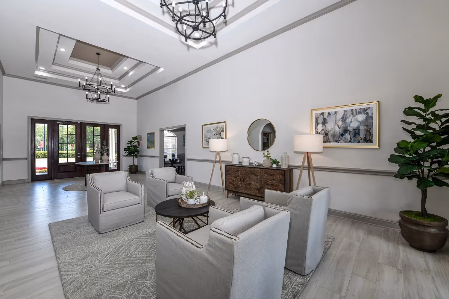 Elegant resident clubhouse lobby with comfortable seating, decorative mirrors, and modern chandeliers at The Finley in Jacksonville, FL.