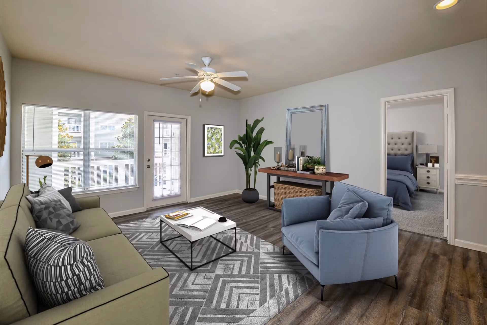 Modern apartment living room with a sofa, armchair, and balcony access, offering an open view into the bedroom at The Finley in Jacksonville, FL.