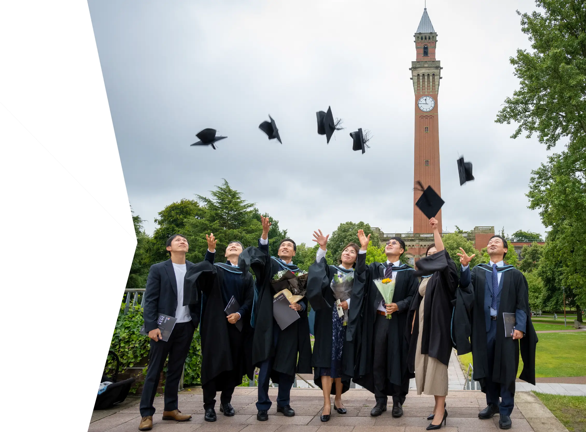 A group of University of Birmingham graduates throwing their hats into the air