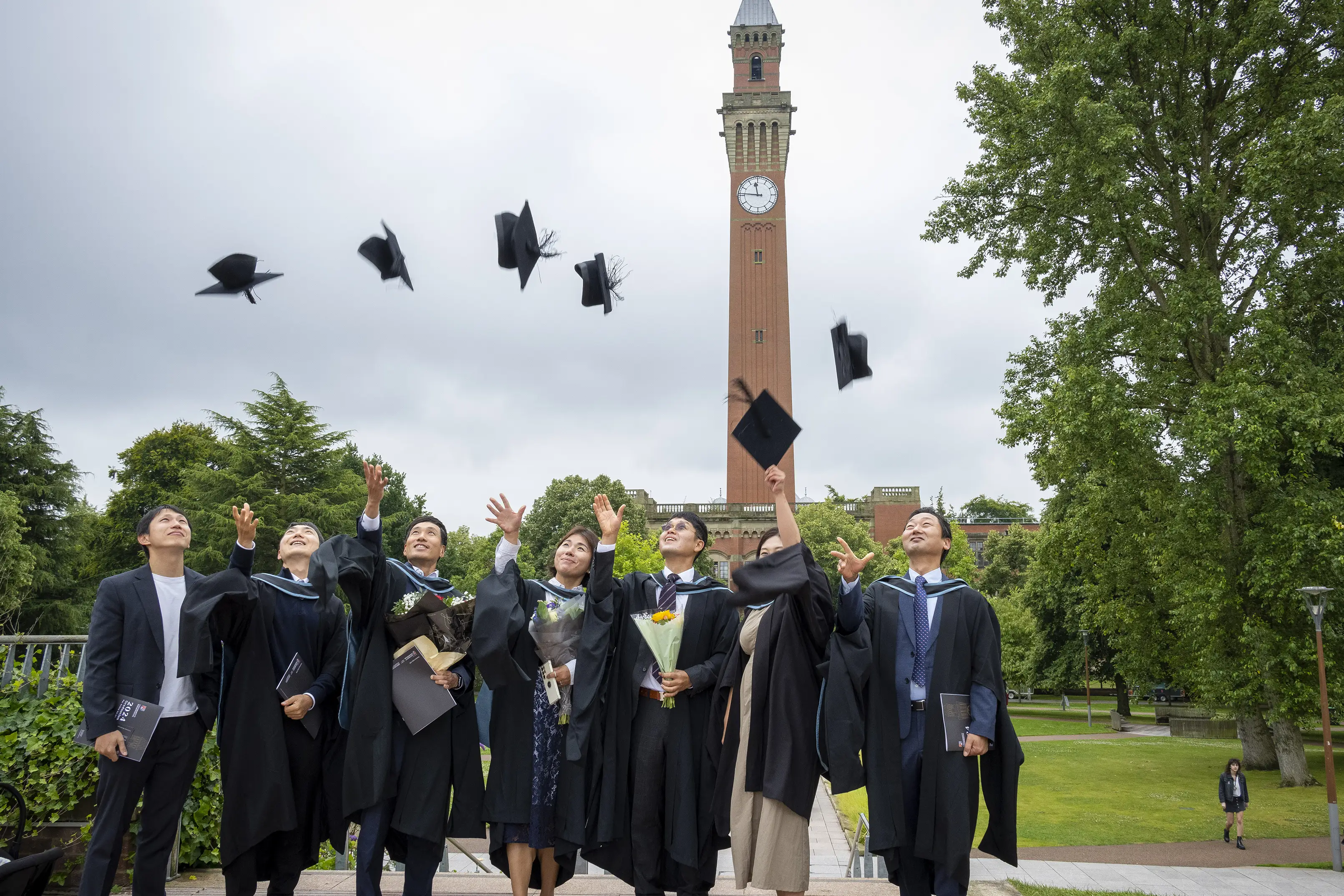A group of University of Birmingham graduates throwing their hats into the air