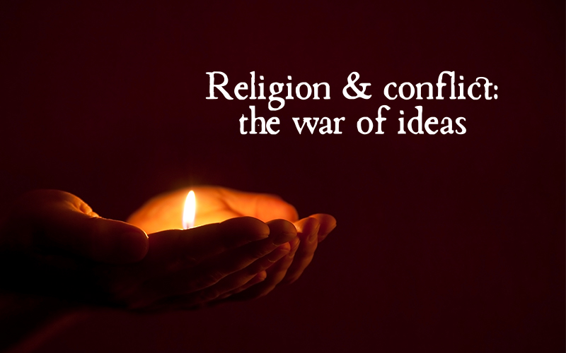Hands holding a candle in a dark environment, the words "Religion and conflict: the war of ideas" accompanying it. 