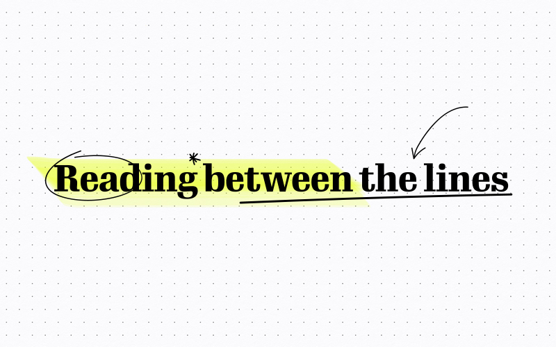 The title "Reading between the lines" written on paper, select words have been highlighted and arrows drawn in between the letters - as if notes taken. 