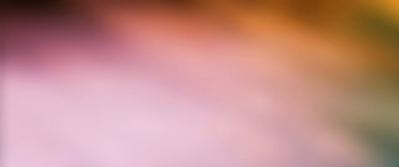 Blurred gradient background with soft shades of pink, orange, and green.