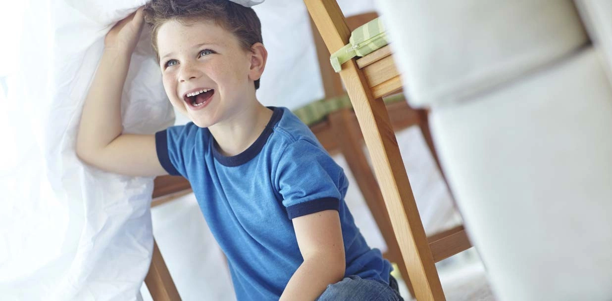 Child plays with toy near air purifier.