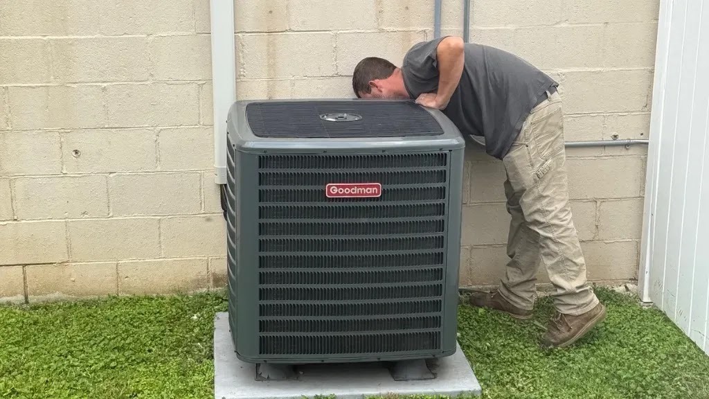 HVAC technician diagnosing an air conditioning unit for leaks and faults