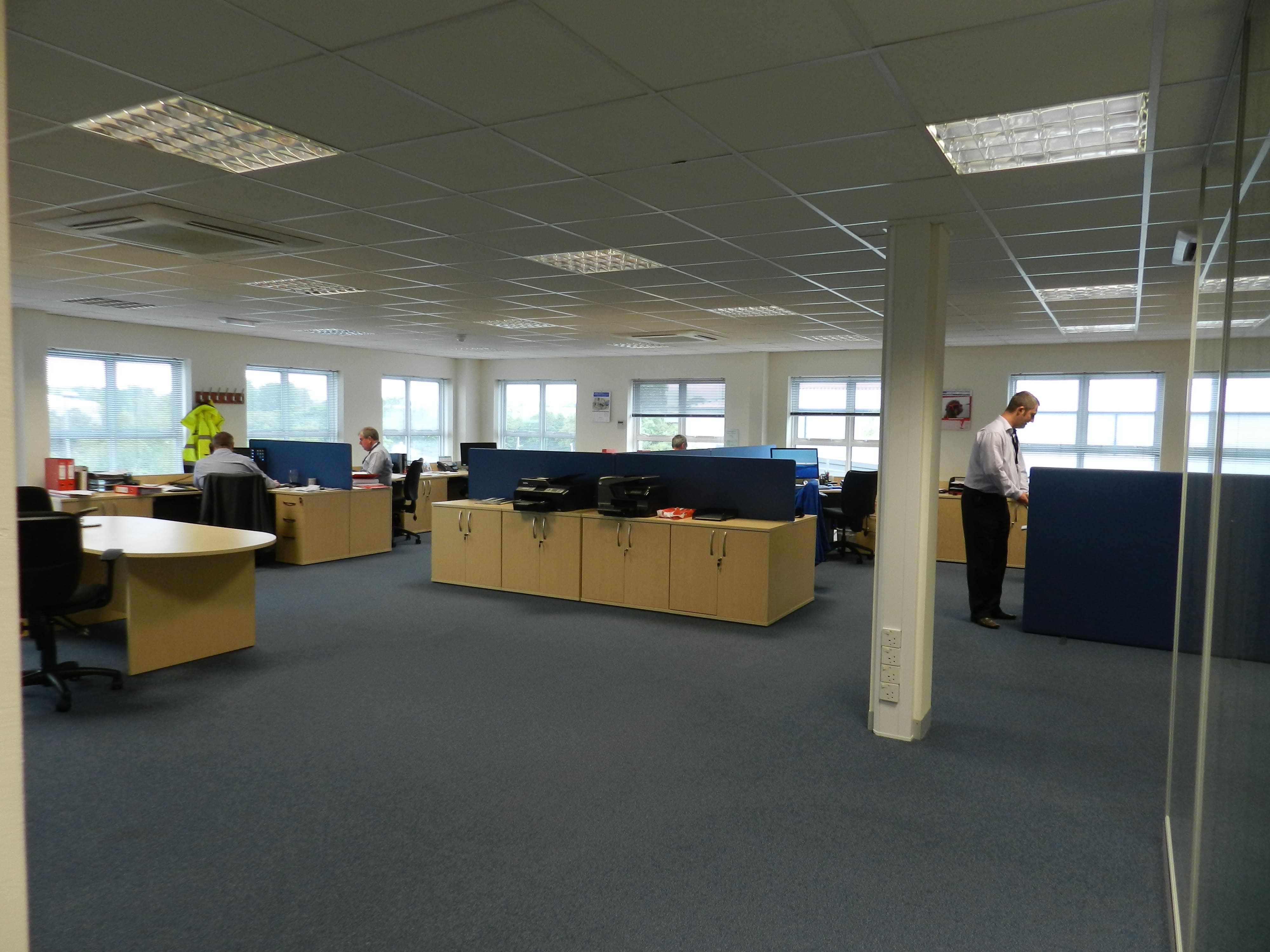 Greens Combustion office space in 2012 with employees working at desks in an open-plan workplace, marking the company’s launch year.