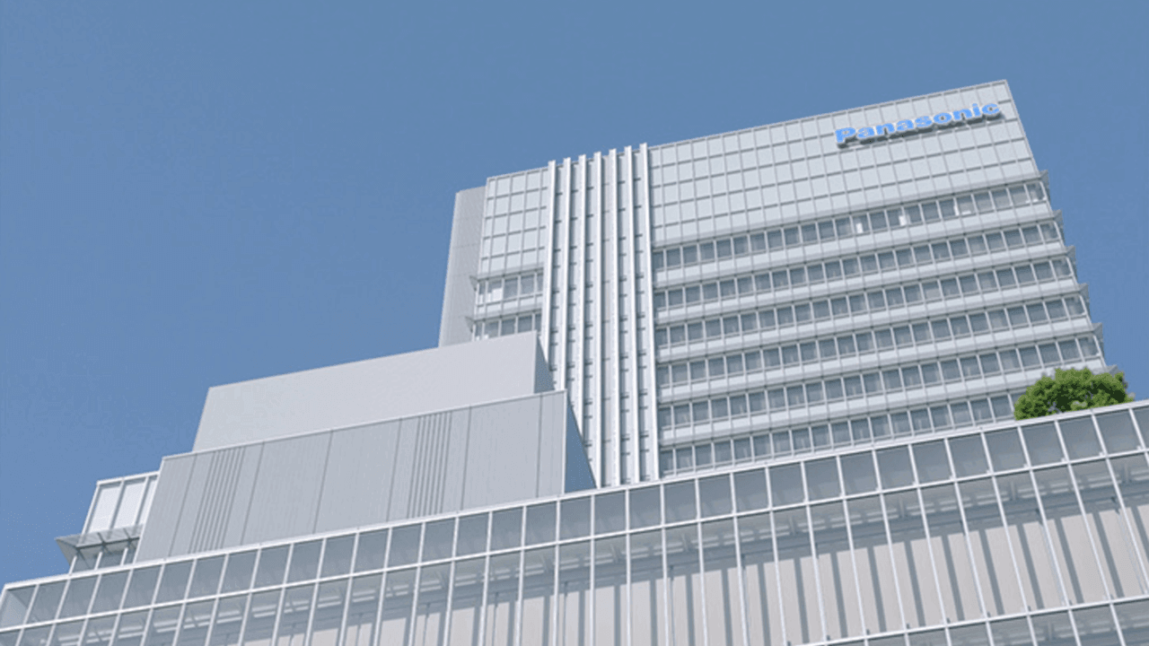 Modern high-rise building with Panasonic logo against clear blue sky.