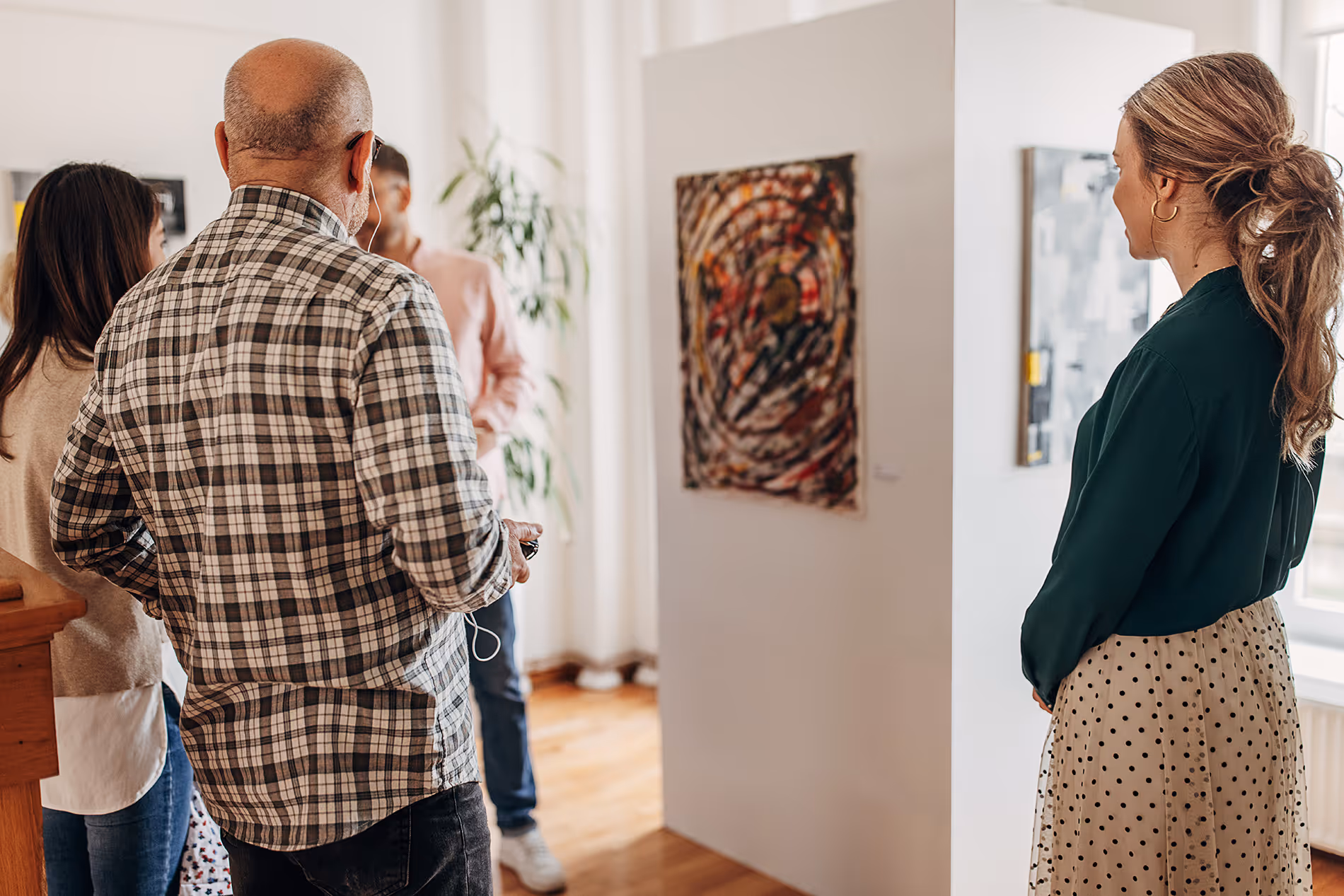 Visitors exploring exhibits at a local art museum, observing artwork and enjoying the cultural experience.