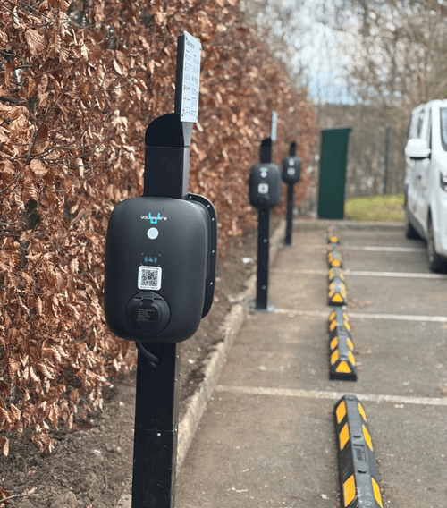 Photo of a row of voltshare EV chargers on posts in a state funded school.