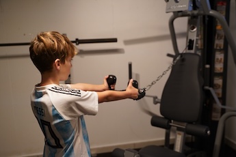 Junger Fußballer trainiert am Kabelzug im Coach2pro Studio