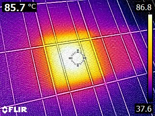 Immagine termica che mostra una superficie con un punto centrale molto caldo a 85,7°C, circondato da zone più fredde rappresentate in viola e blu.