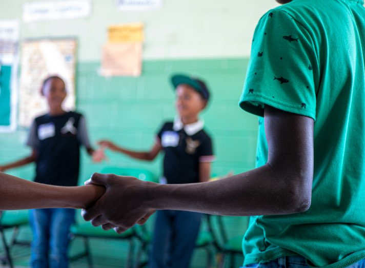 Kids holding hands in a classroom