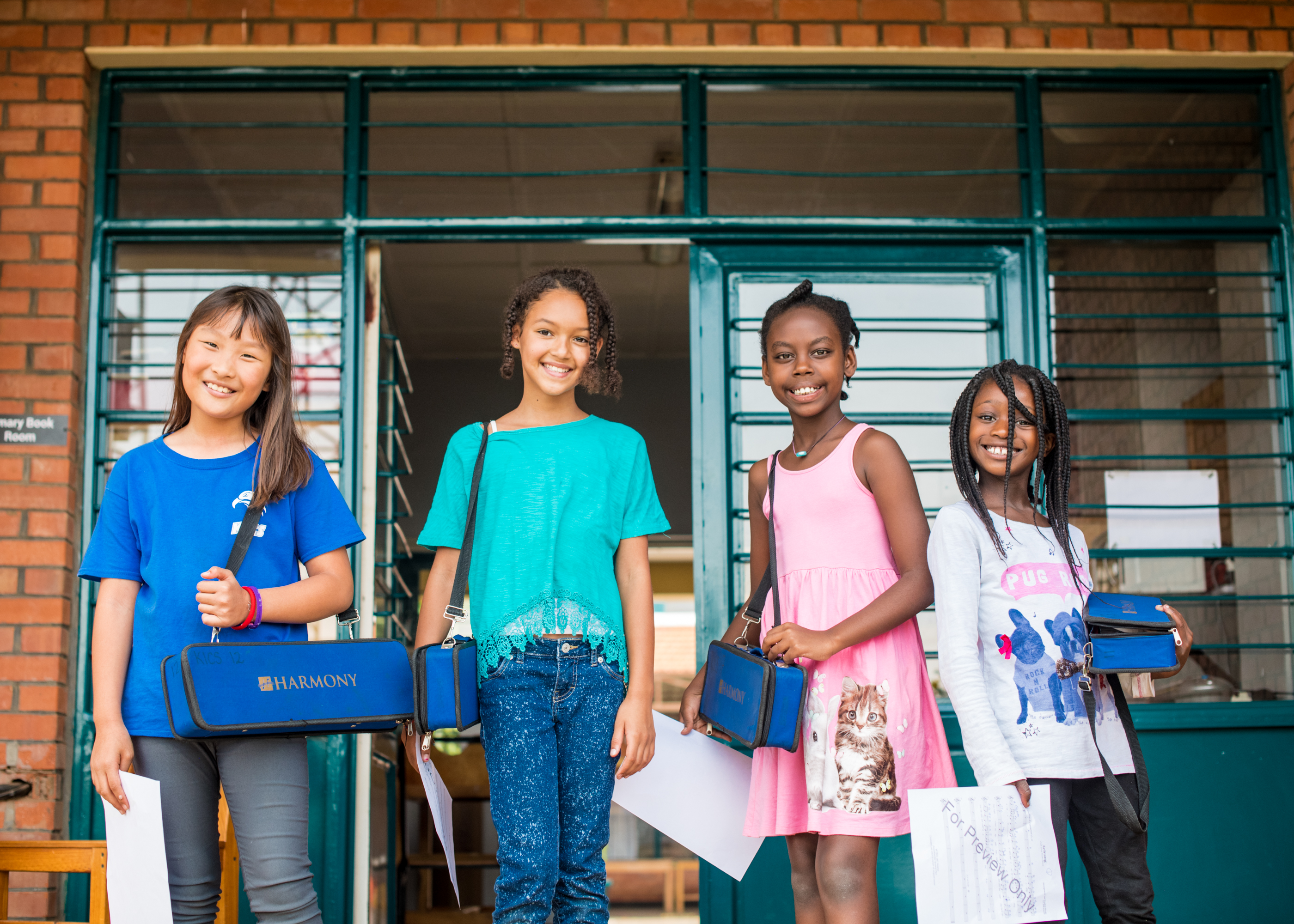 Children smiling in front of the entrance to their classroom