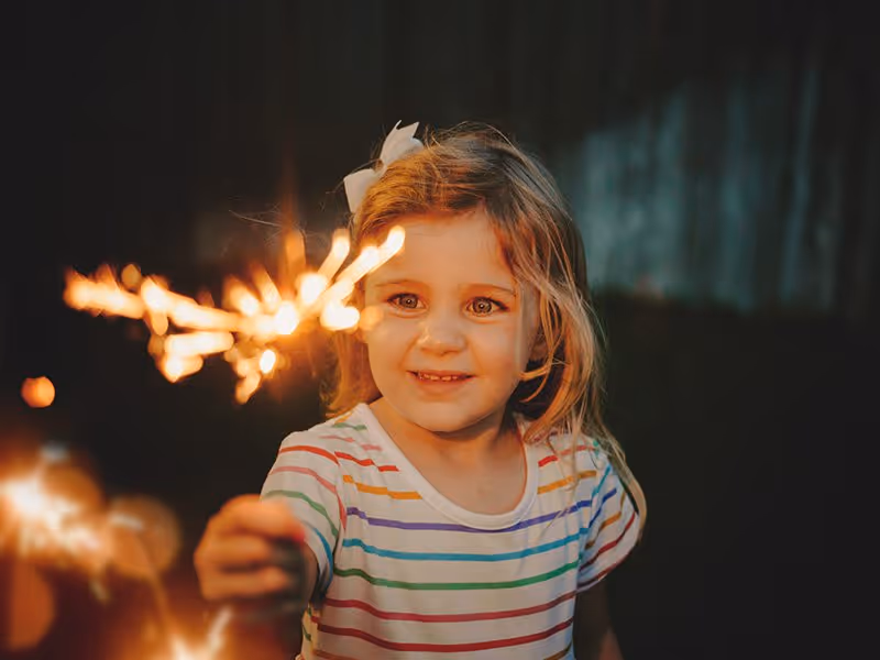 little girl with sparkler on fourth of july