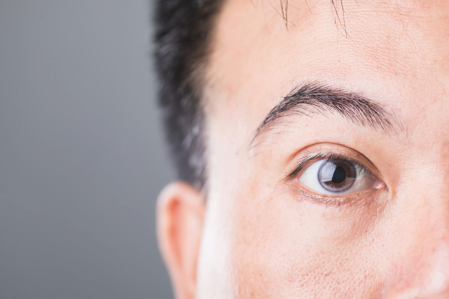Close-up of a man’s eye showing detailed iris and pupil, illustrating vision health and potential complications such as diabetic retinopathy.