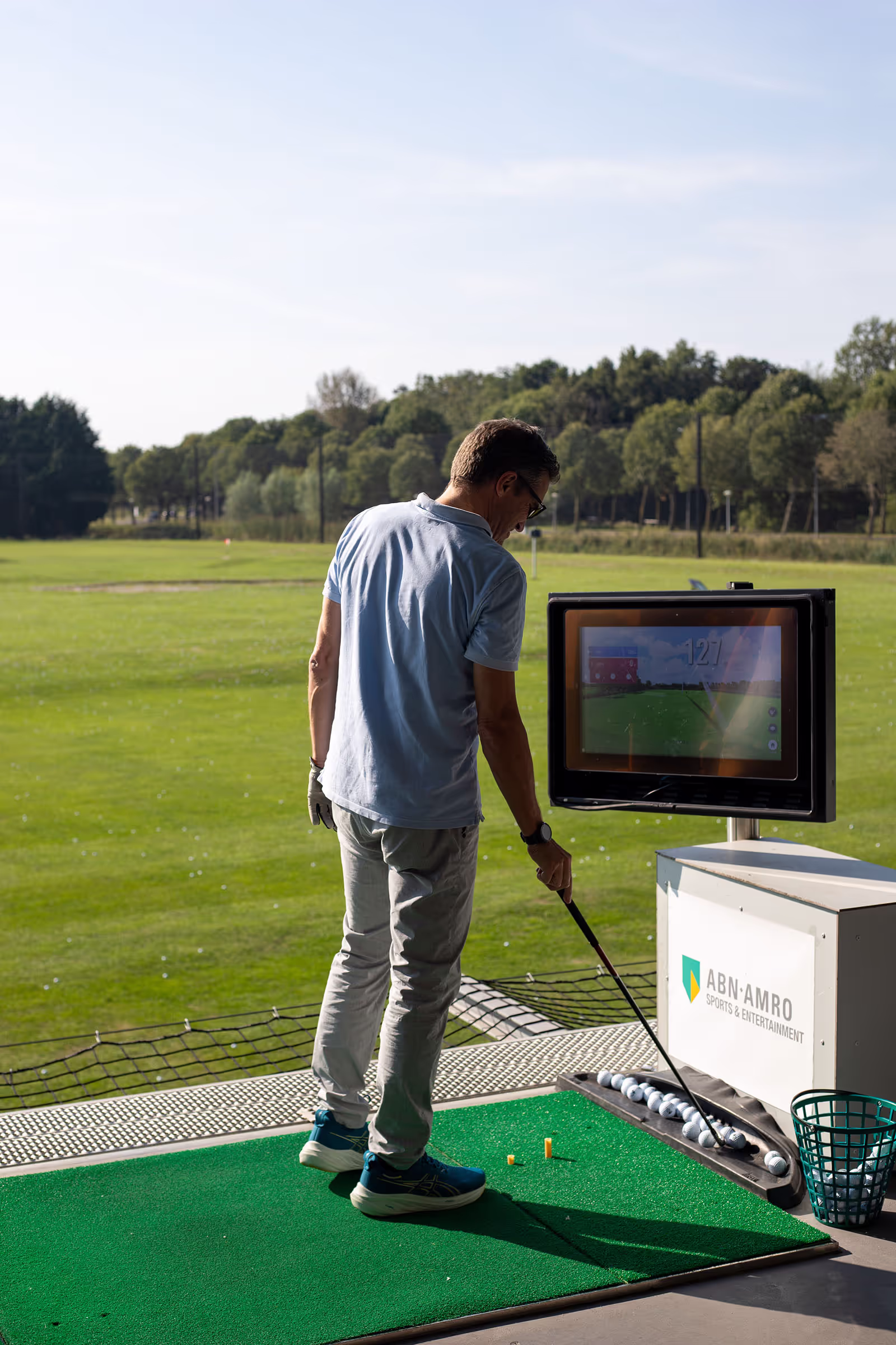 Man op op zonnige driving range