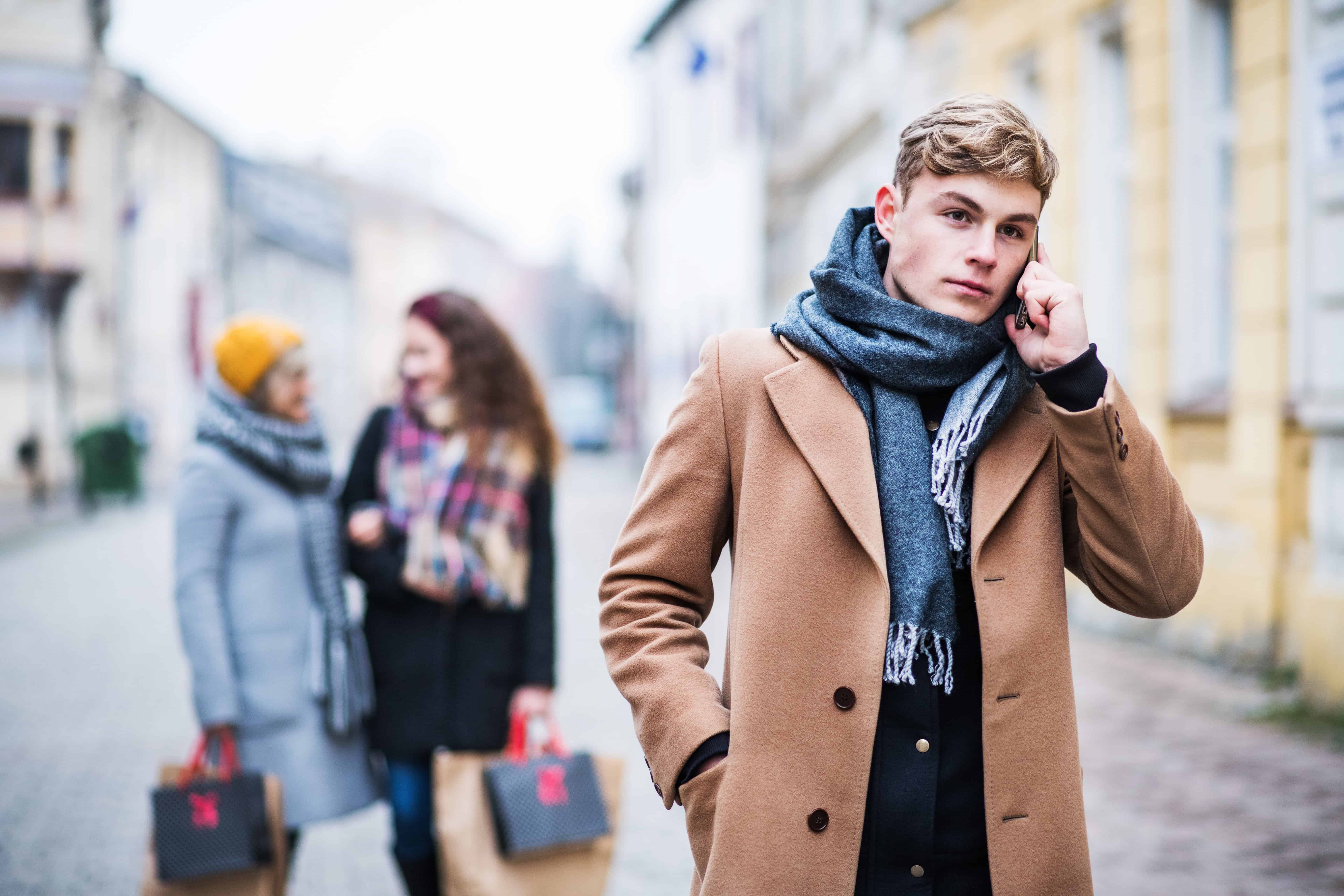 man in fashionable outdoor wear walking on shopping street