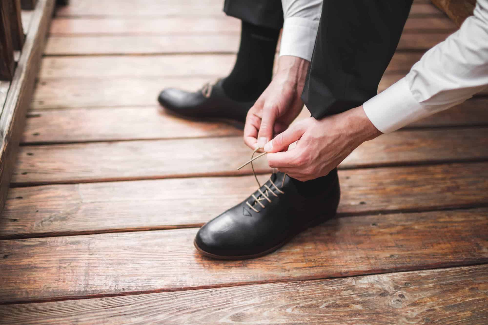 closeup of man tying dress shoelaces