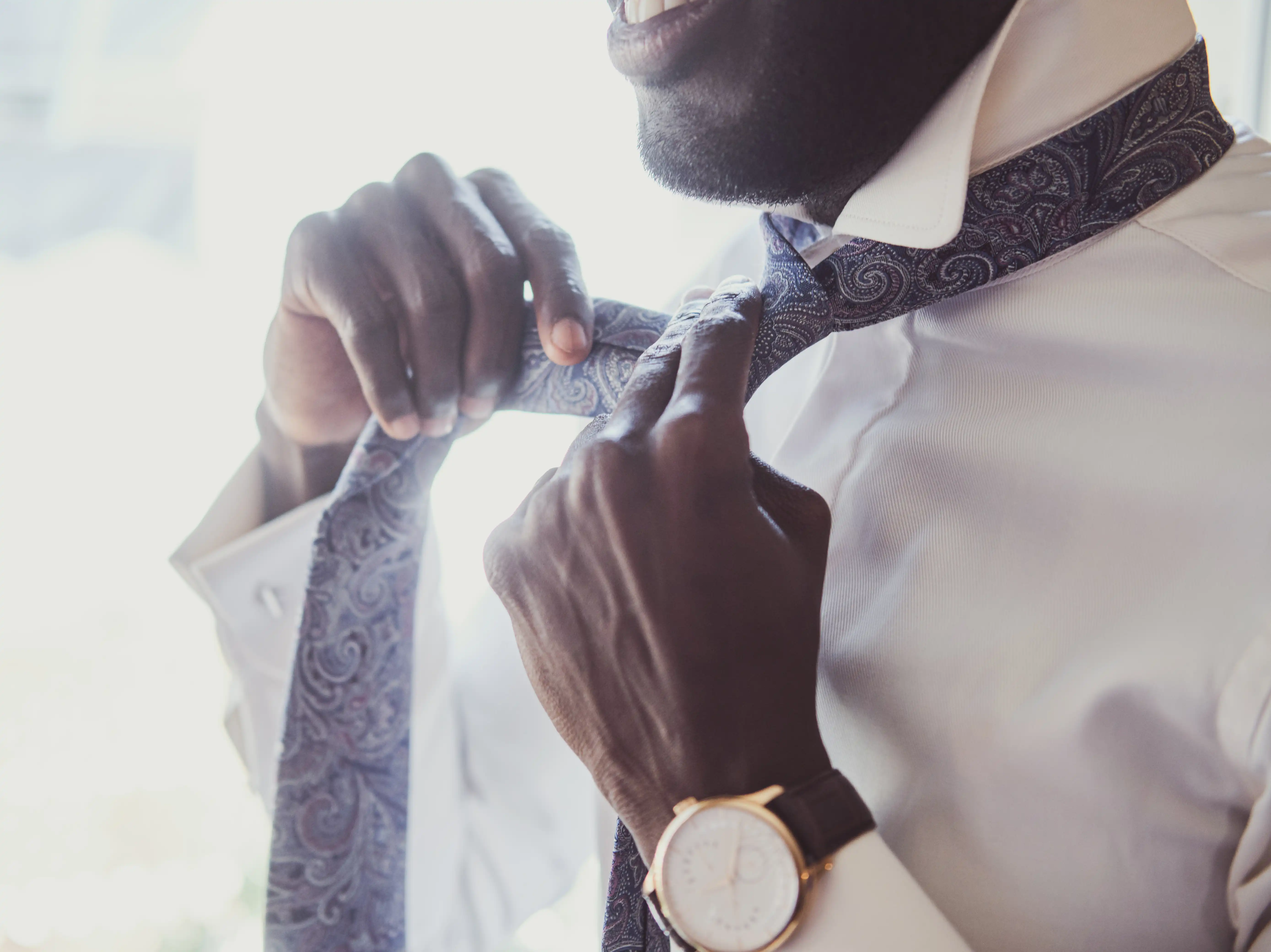 closeup of man tying tie wearing fashionable watch