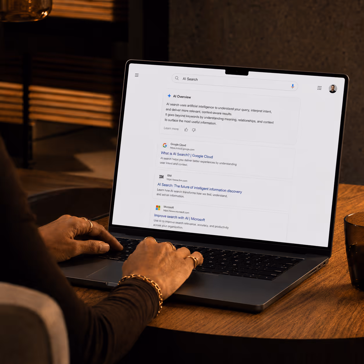 Person using a laptop showing AI Search results