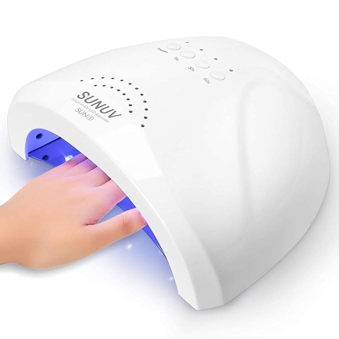 Hand under a white SUNUV UV LED nail lamp curing nails with blue light.