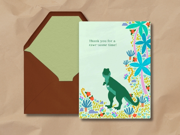 Thank you card with green T-Rex dinosaur and colorful tropical plants, closed brown envelope beside it.