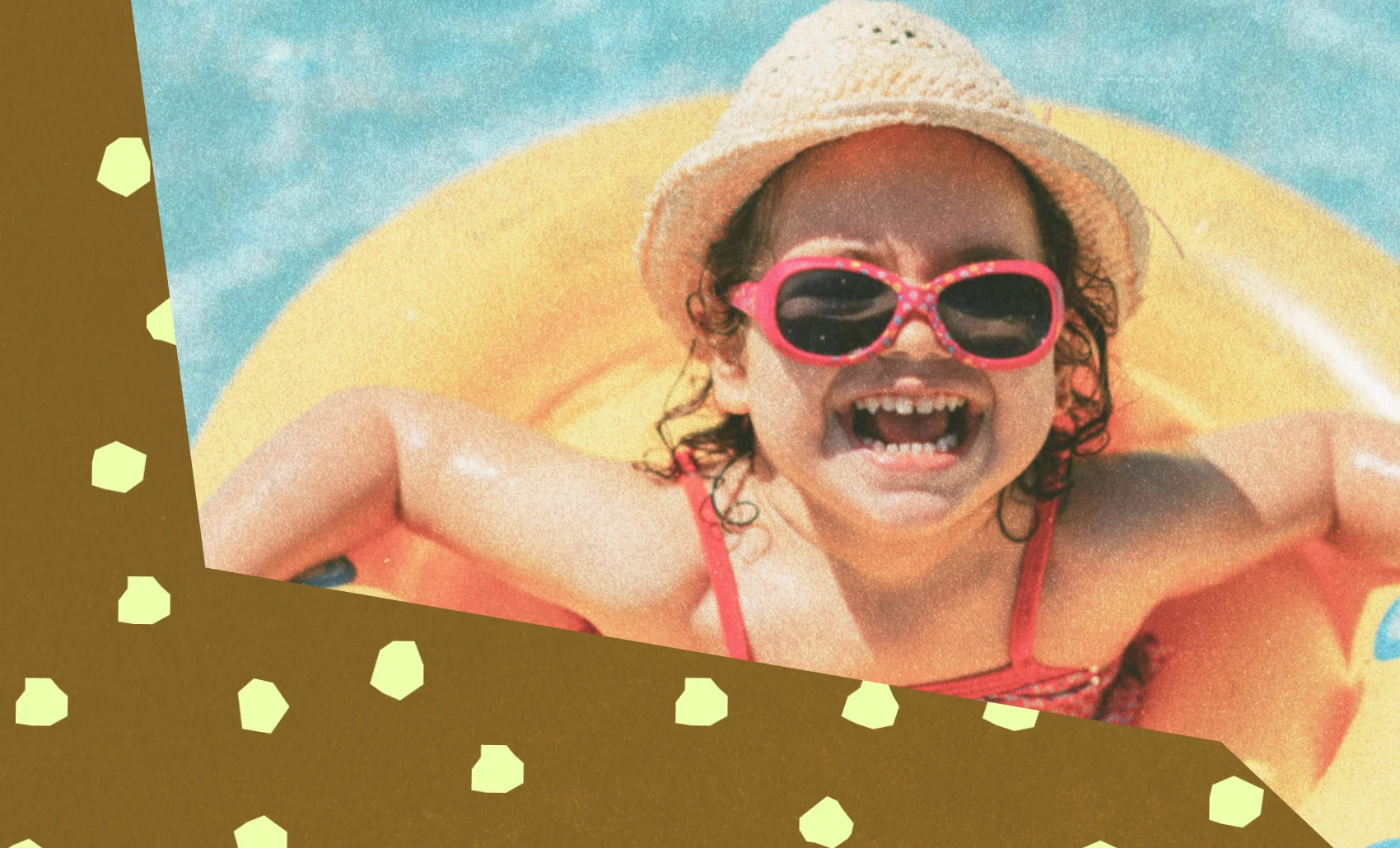 Smiling child wearing pink sunglasses and a hat floats in a yellow pool ring on blue water.