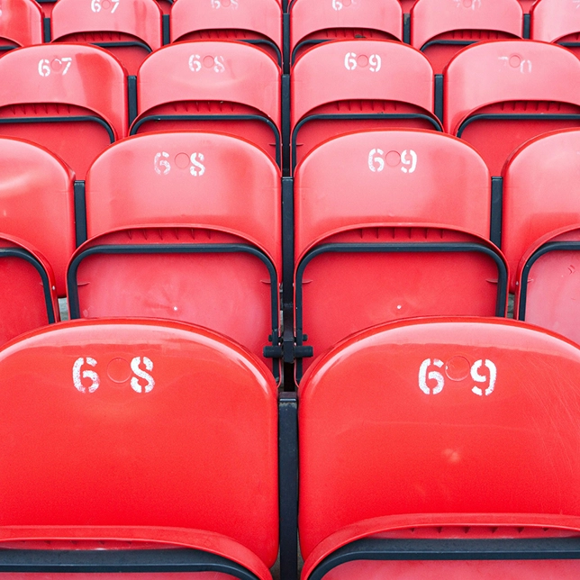 Rows of empty red stadium seats numbered 68 and 69 in alternating pattern.