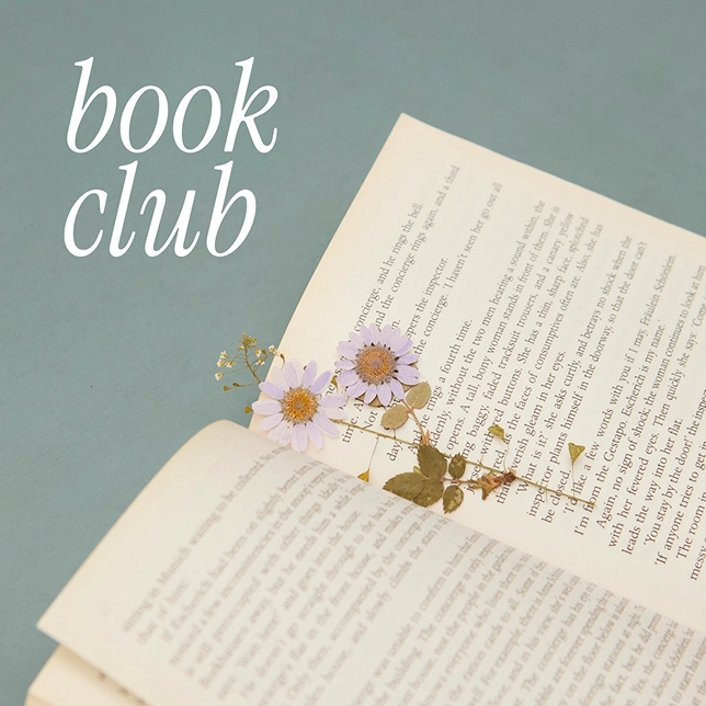 Open book with pressed purple flowers between pages and 'book club' text on blue background.