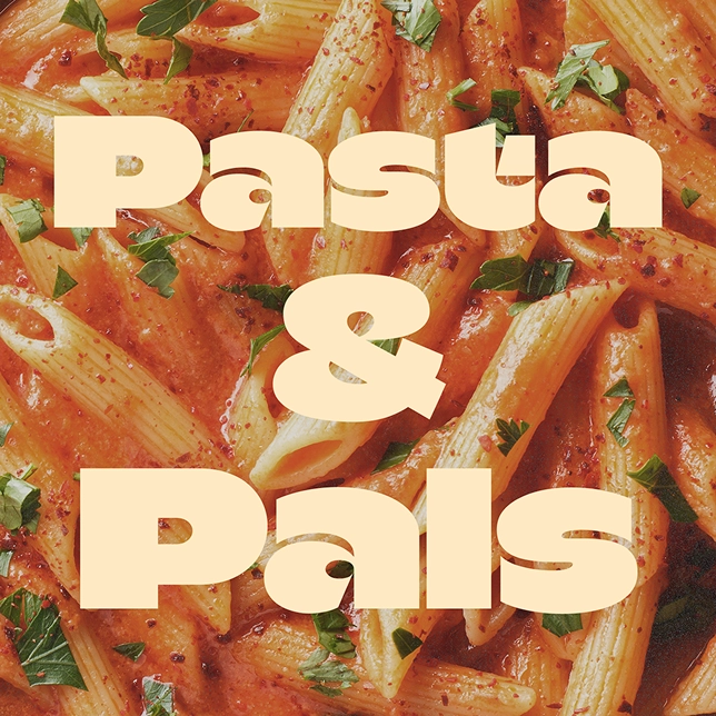 Penne pasta in red sauce garnished with chopped green herbs with text Pasta & Pals overlay.