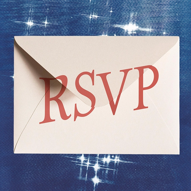 White envelope with red RSVP letters on a dark background with white star-like sparkles.